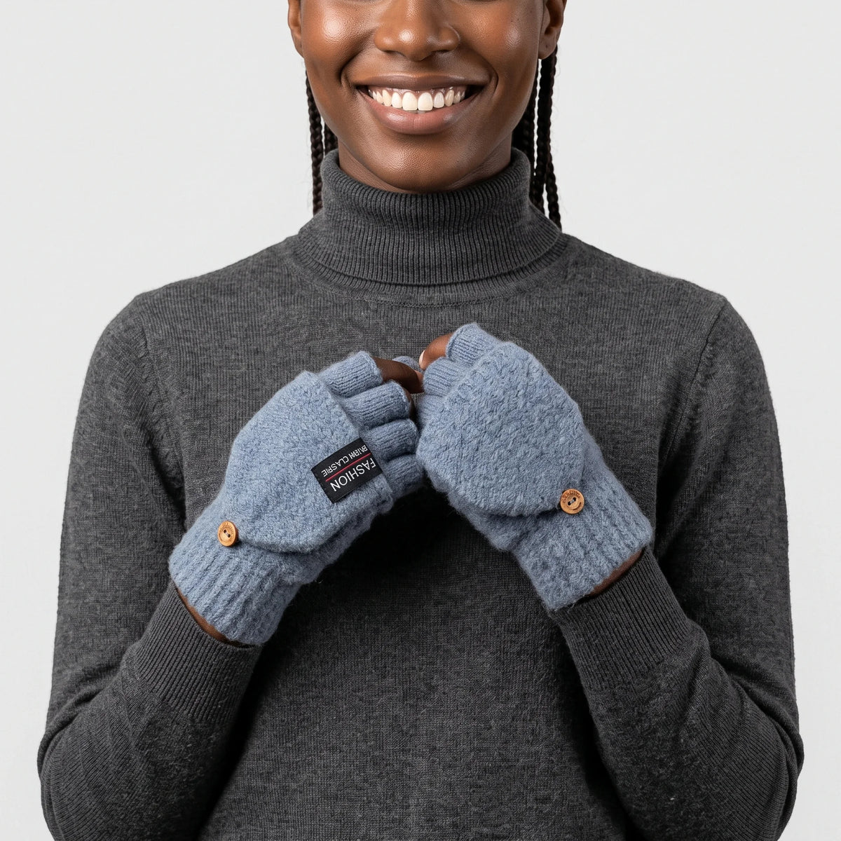 Mitaines chauffantes à rabat bleu gris portées par une femme souriante en pull anthracite