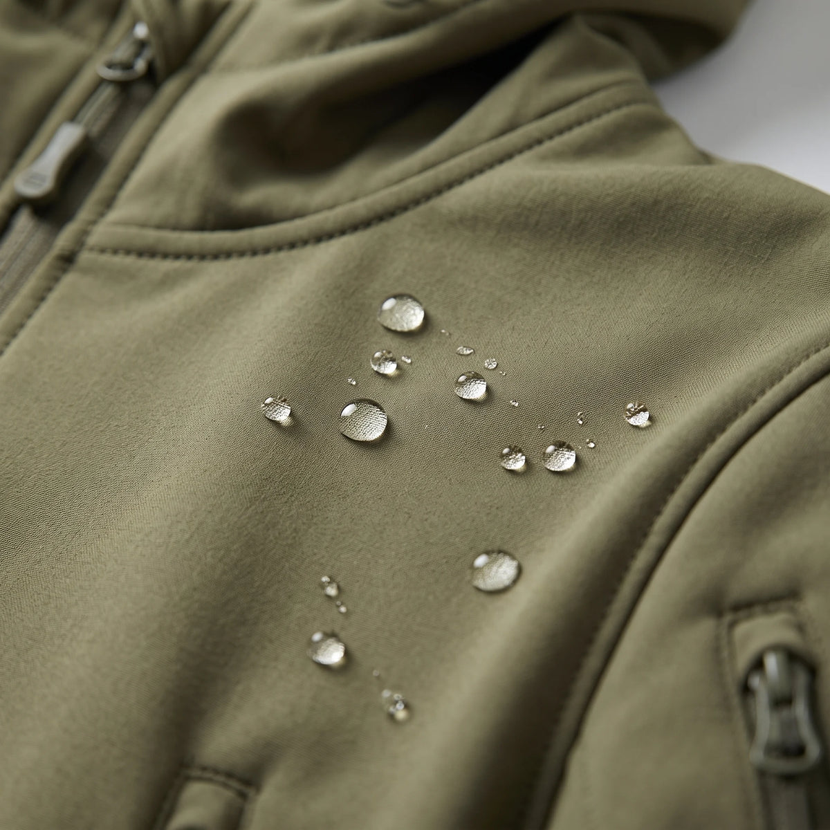 Gouttes d'eau qui perlent sur le softshell déperlant de la veste vert armée