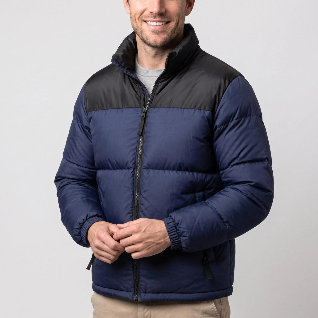 Doudoune chauffante bleu marine et noir portée par un homme souriant, les mains jointes