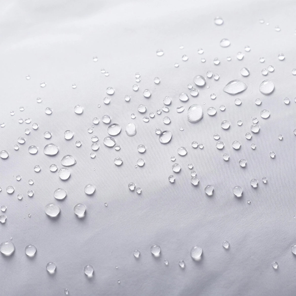 Gouttes d'eau qui perlent sur le tissu de la doudoune gris clair