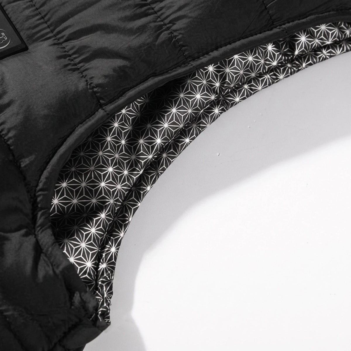 Emmanchure du gilet noir et sa doublure imprimée d'étoiles