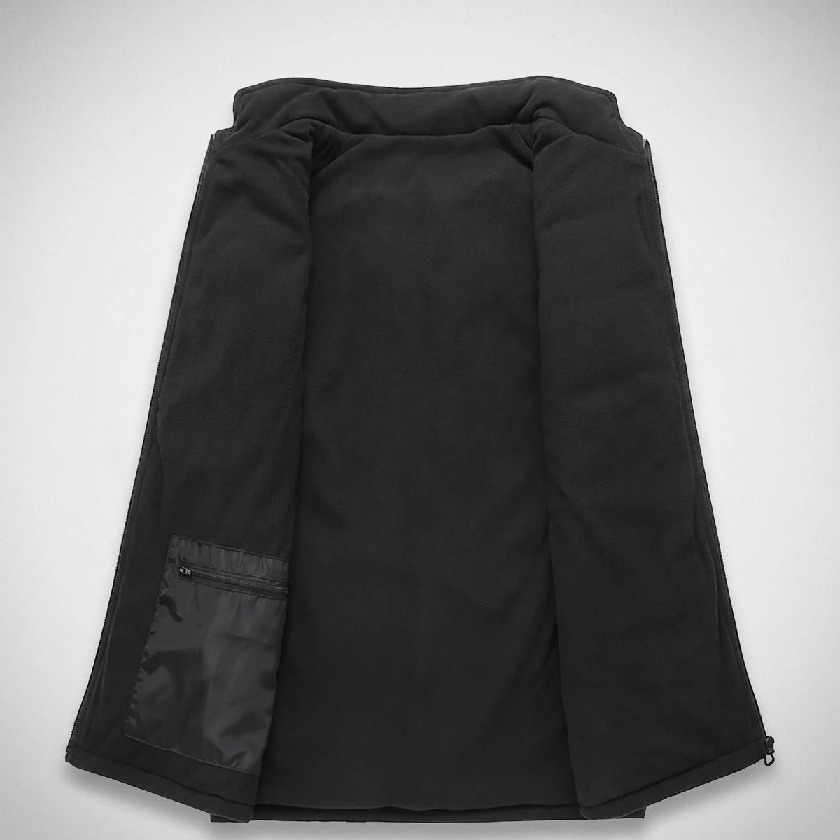 Intérieur du gilet chauffant : doublure polaire noire et poche zippée pour la batterie