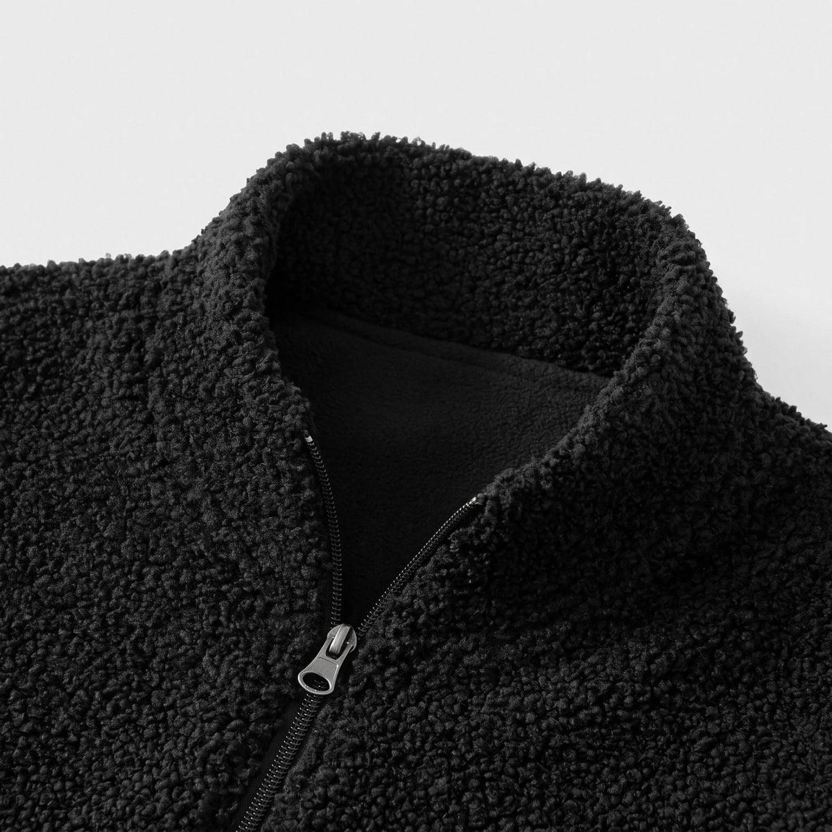 Col court du gilet en polaire sherpa, doublure noire et fermeture éclair