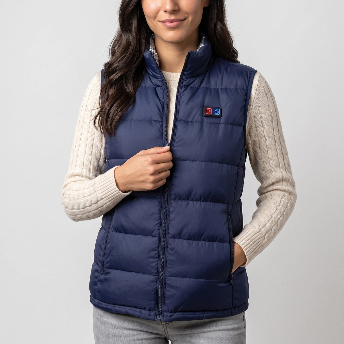 Gilet chauffant bleu marine porté par une femme souriante, pull crème