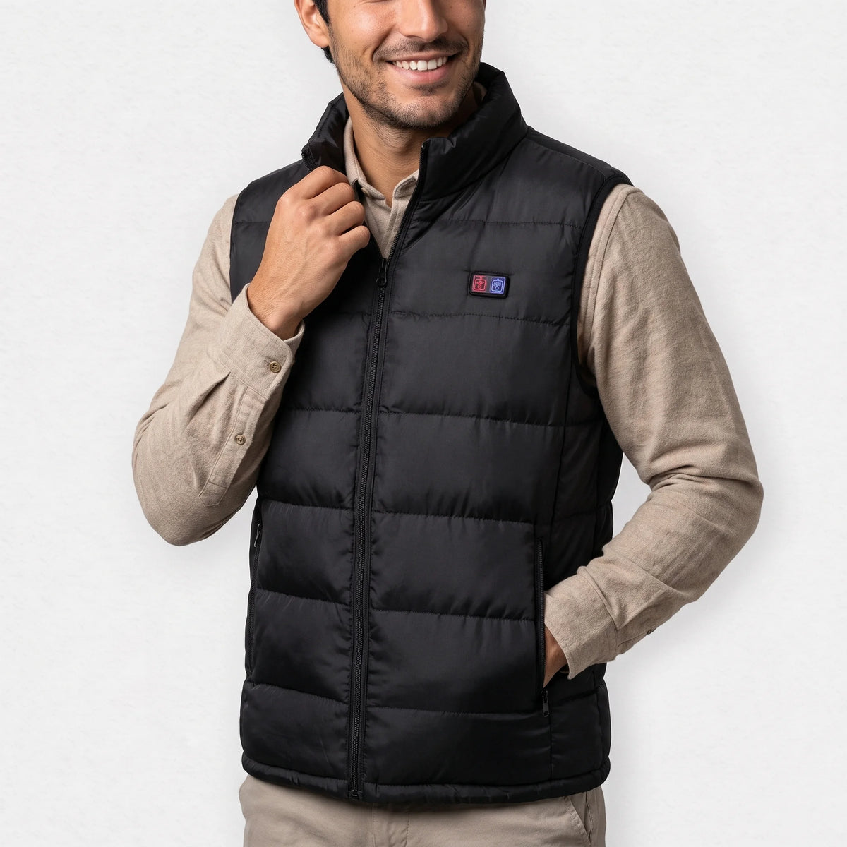 Gilet chauffant noir porté par un homme souriant, chemise sable