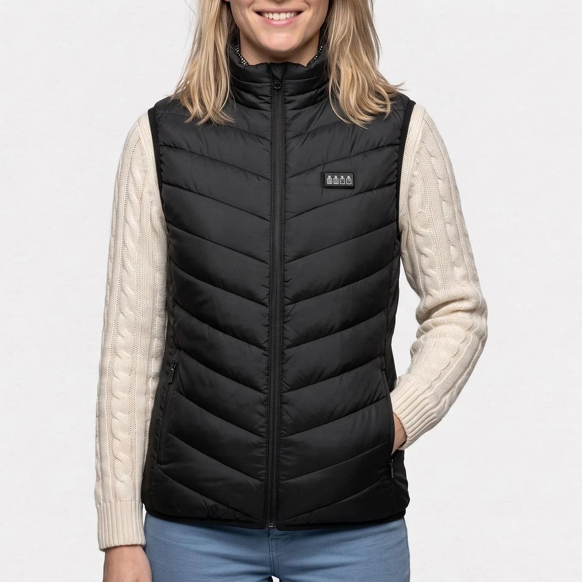 Gilet chauffant noir porté par une femme souriante, une main dans la poche