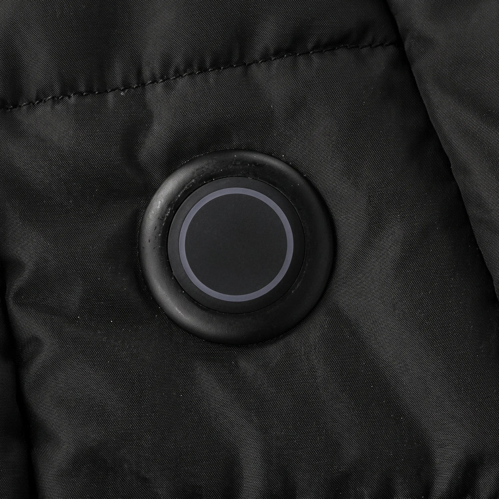 Bouton de chauffe rond et lumineux sur le bas du devant de la parka