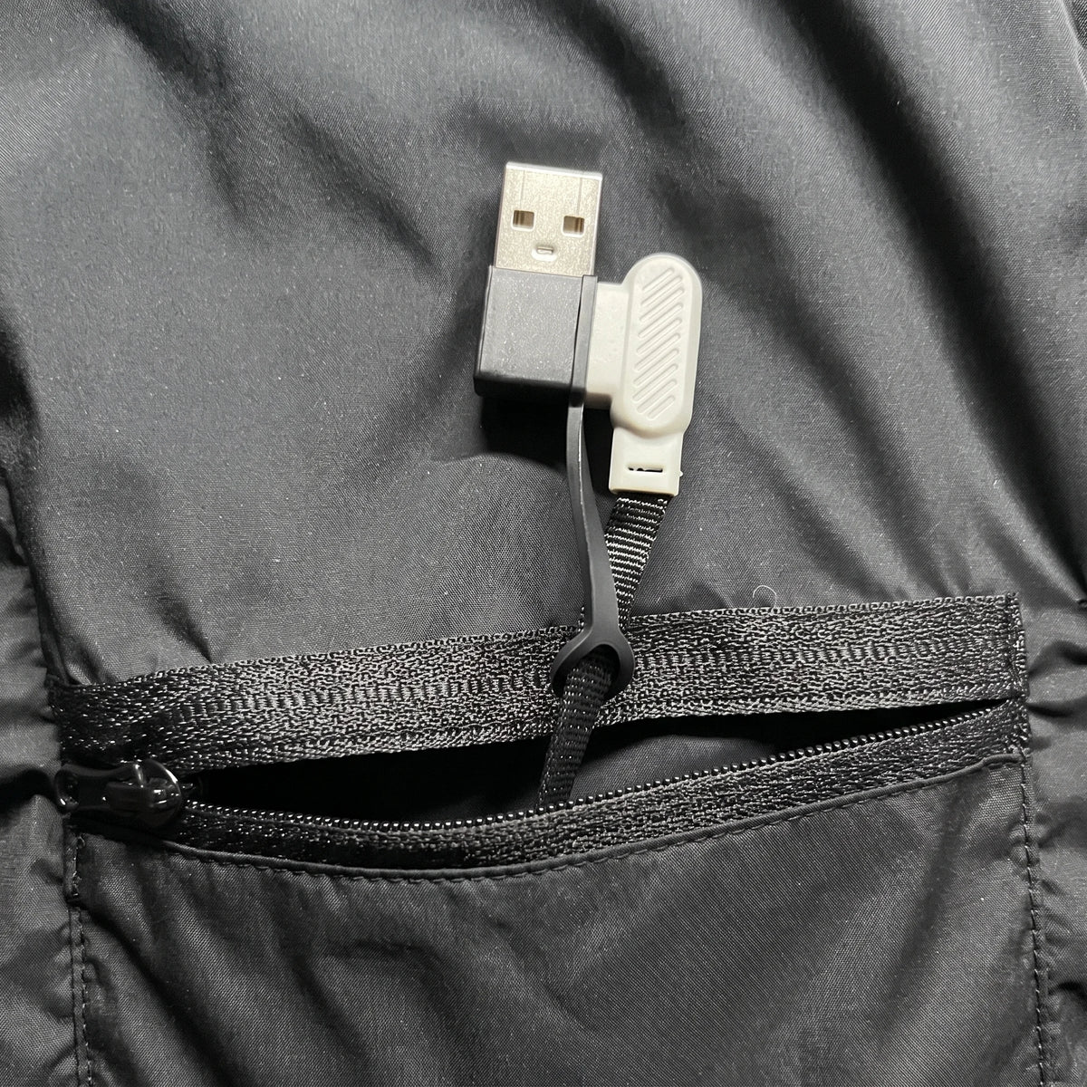 Prise USB et son capuchon dans la poche intérieure, batterie non incluse