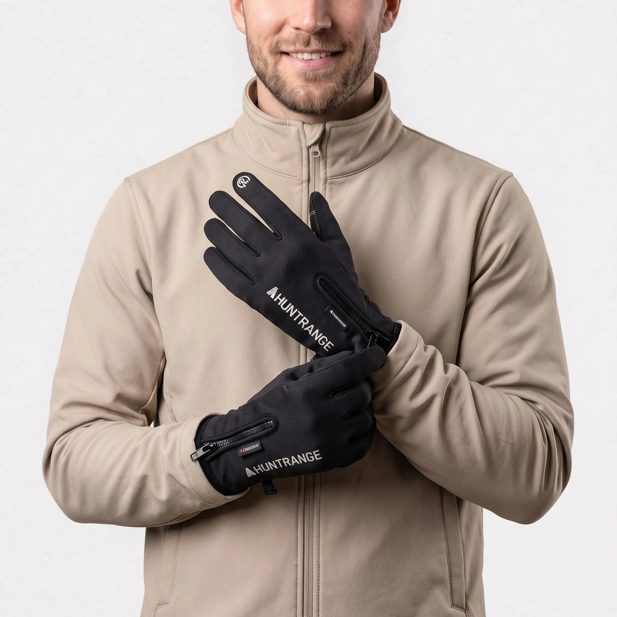 Gants chauffants fins noirs portés par un homme en veste softshell, zip au poignet