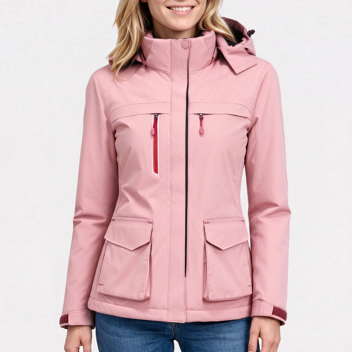 Veste de ski chauffante rose poudré portée par une femme souriante