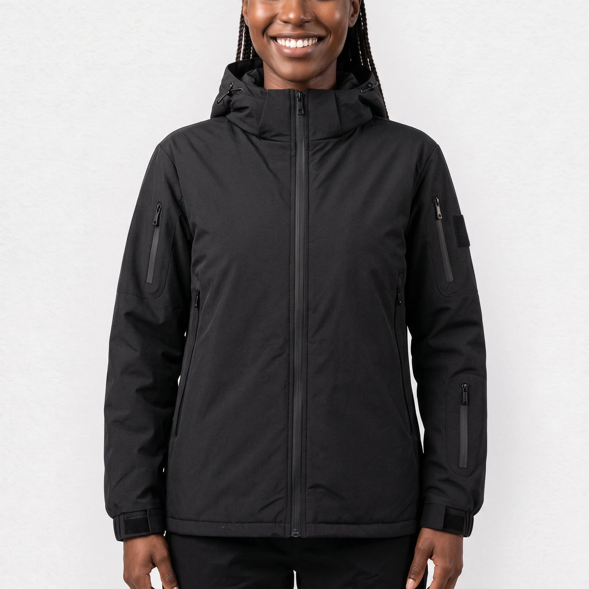 Veste chauffante noire à capuche portée par une femme souriante
