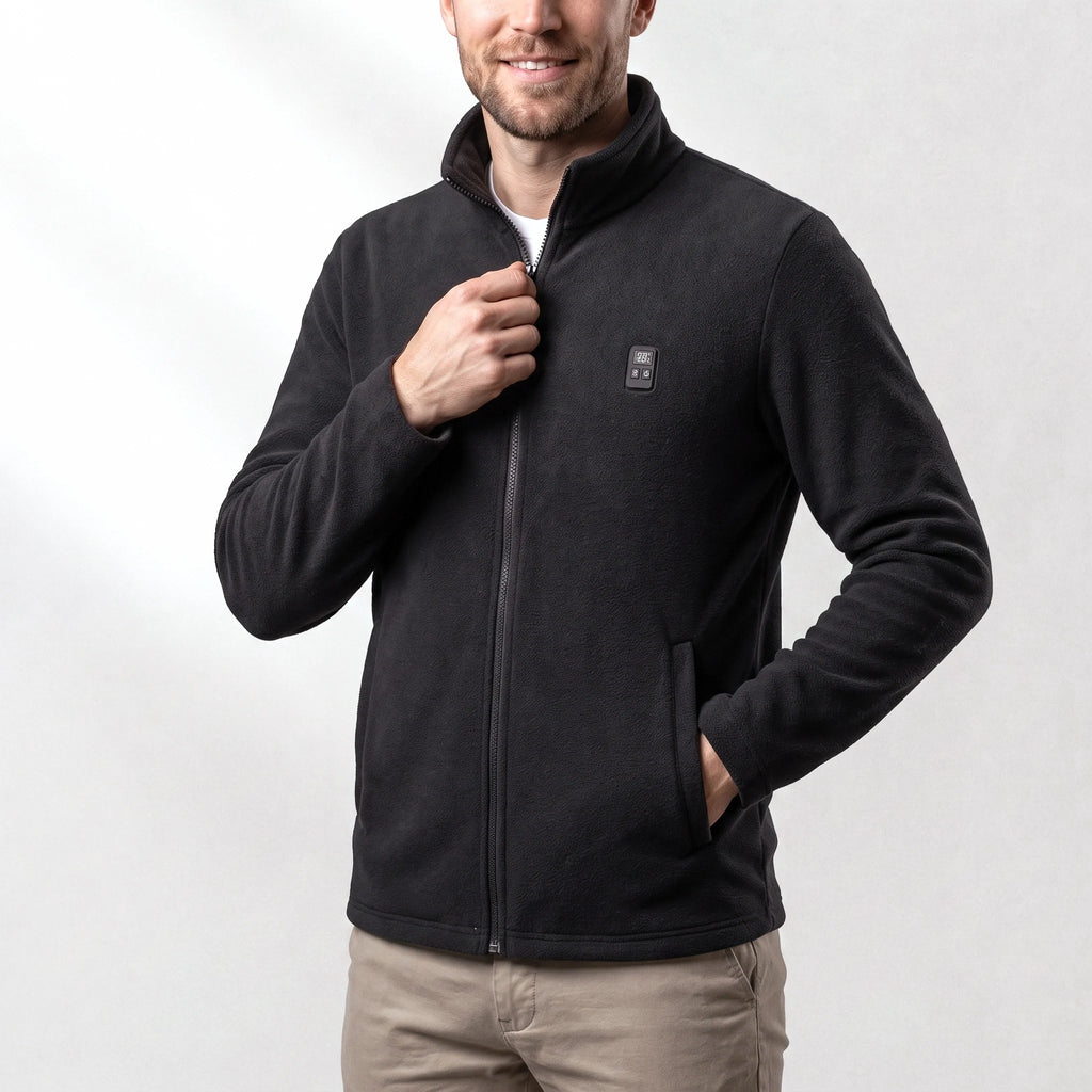 Veste polaire chauffante noire portée par un homme souriant, une main dans la poche