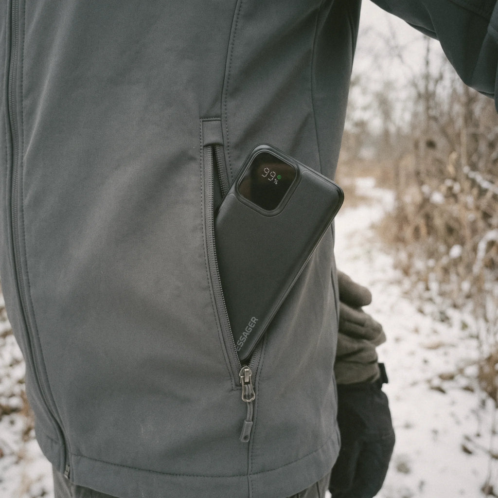 Batterie externe glissée dans la poche zippée d'une veste en hiver